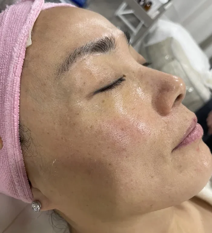 Student practicing a professional facial treatment during esthetics training