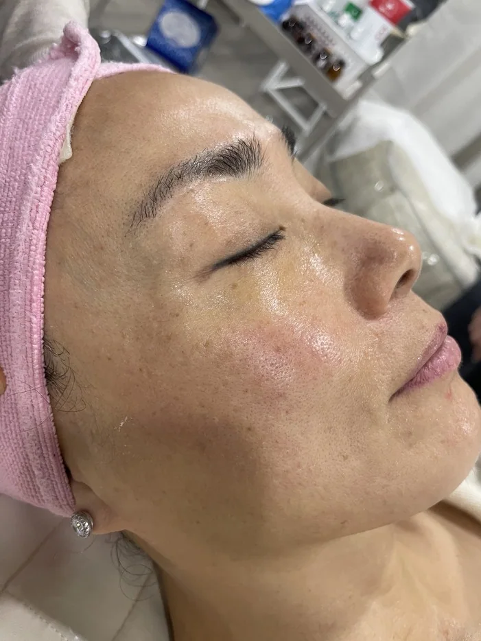 Student practicing a professional facial treatment during esthetics training
