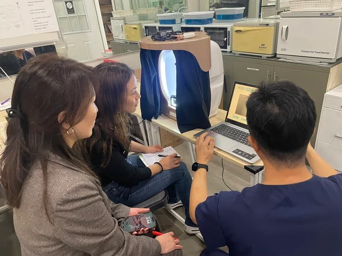 Esthetics instructor guiding a skin analysis lesson at RT7 Beauty College