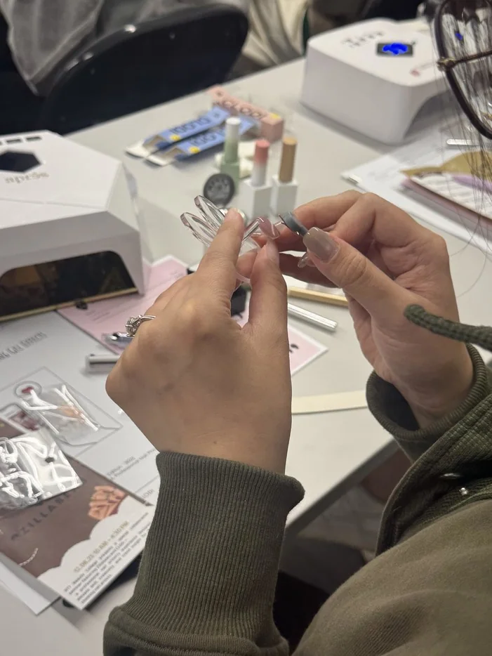 Hands-on nail tip application practice in the RT7 Beauty College nail program